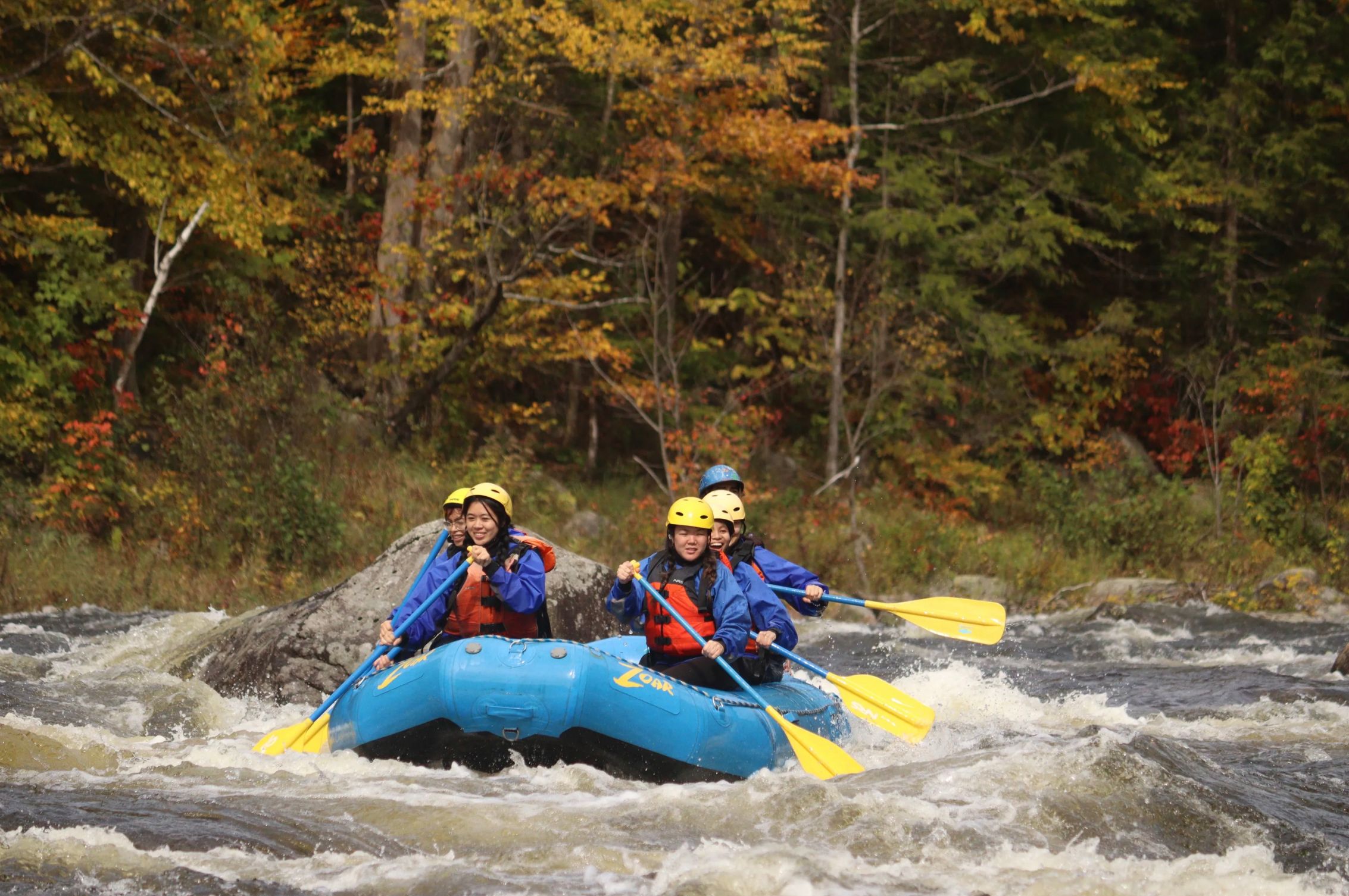 College students in a raft on whitewater adventure