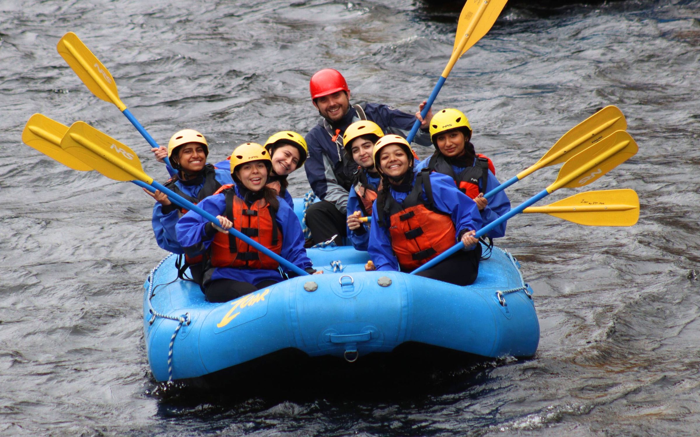 Group of young ladies rafting down the river 